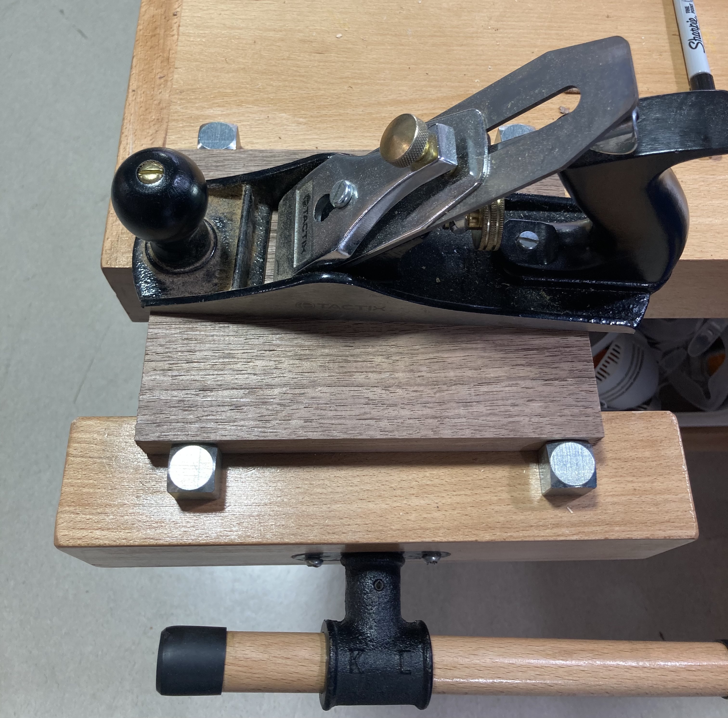 Clamped stock for planing. Note that the stock must be higher than the bench dogs (the metal posts) that are used to hold it.